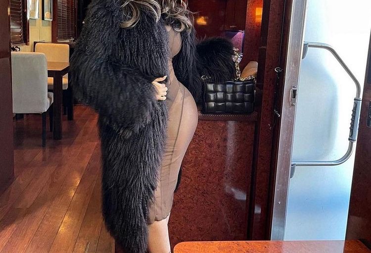 Cardi B Poses Wearing a Brown Dress by Mahjing Wong a Black Vintage Gucci Coat and Bottega Venta Bag